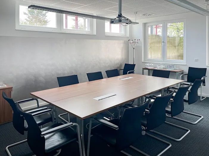 Besprechungsraum mit großem Konferenztisch und Stühlen